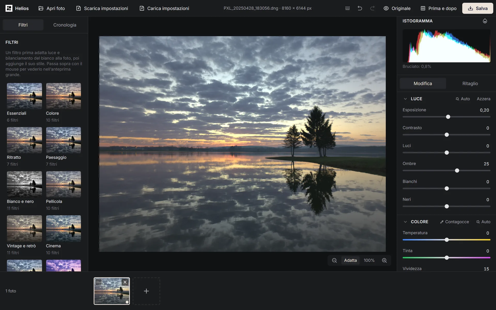 L’editor Helios mostra una foto aperta di un tramonto su un lago, con le categorie di filtri a sinistra e, a destra, l’istogramma e i cursori della luce e del colore.