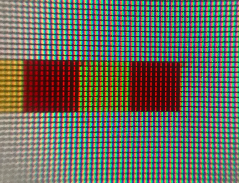 Écran LCD agrandi avec des rangées de bandes rouges, vertes et bleues, où un carré rouge n’allume que les bandes rouges et un carré jaune les bandes rouges et vertes