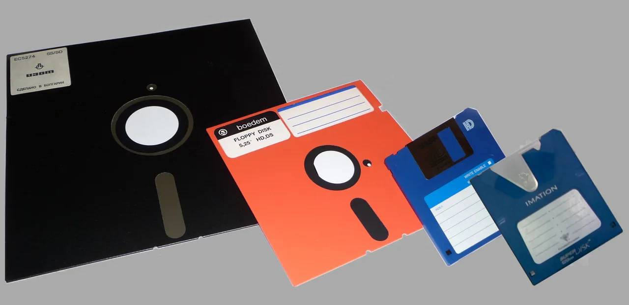 Four generations of floppy disk side by side, from eight inches down to three and a half