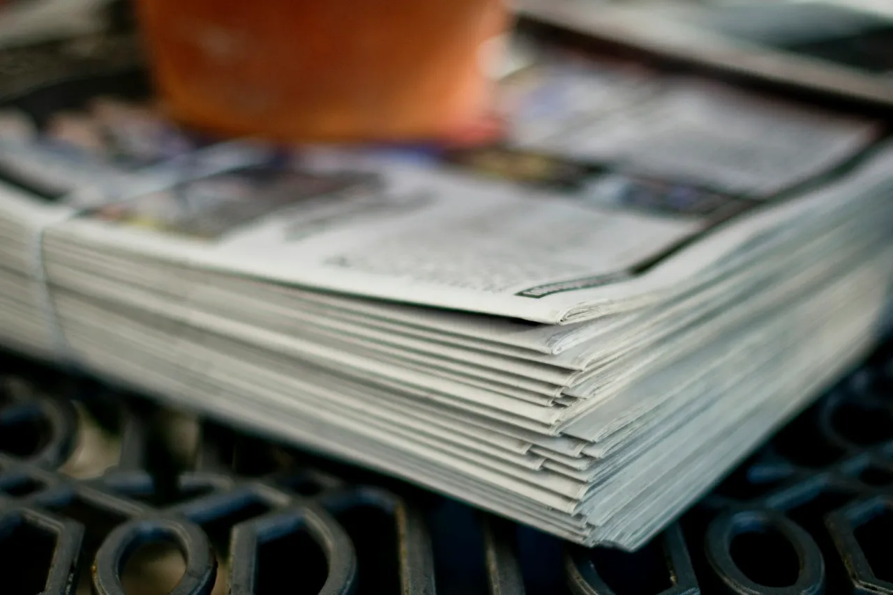 Stos złożonych gazet na czarnym metalowym stole