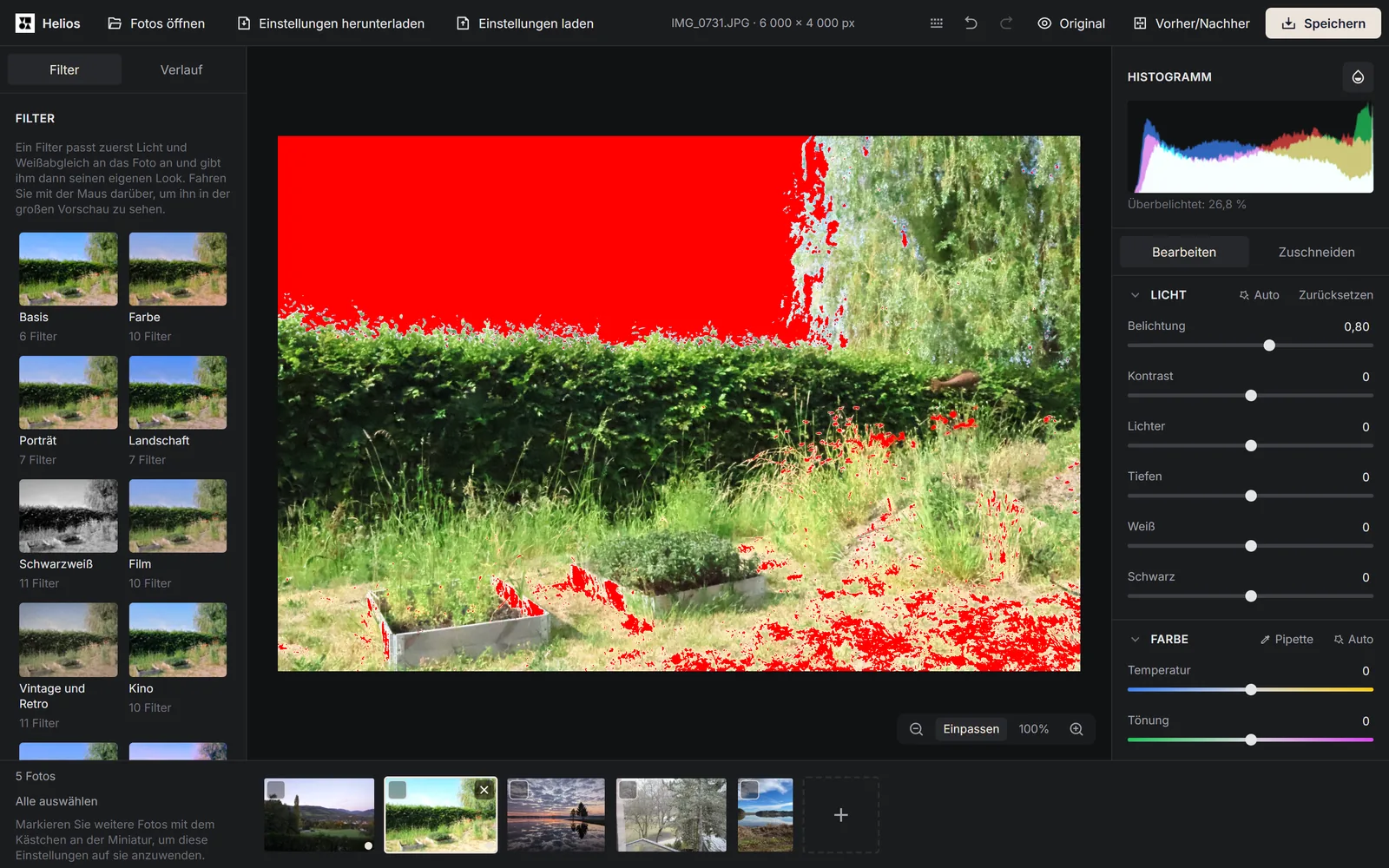 Der Editor Helios mit einem Gartenfoto, auf dem der Himmel und helle Stellen im Gras rot markiert sind, rechts das Histogramm mit dem Hinweis Überbelichtet: 26,8 % und der Regler Belichtung auf 0,80