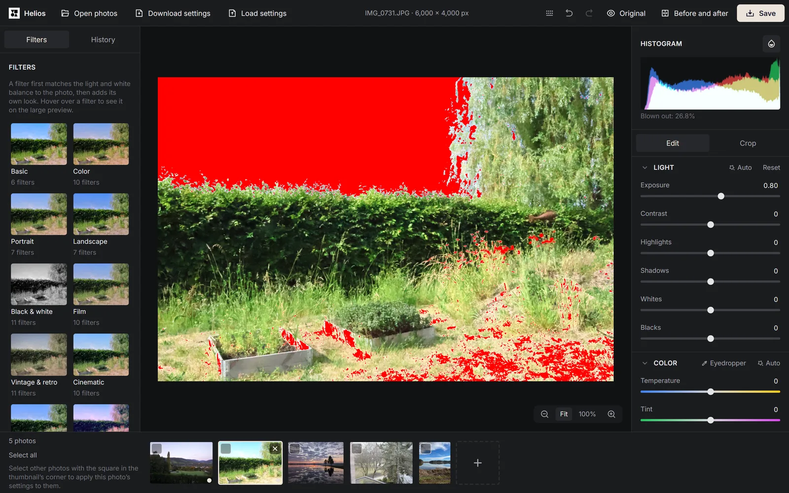 The Helios editor with a garden photo whose sky and bright patches of grass are marked in red, and on the right the histogram with the note Blown out: 26.8% and the Exposure slider at 0.80