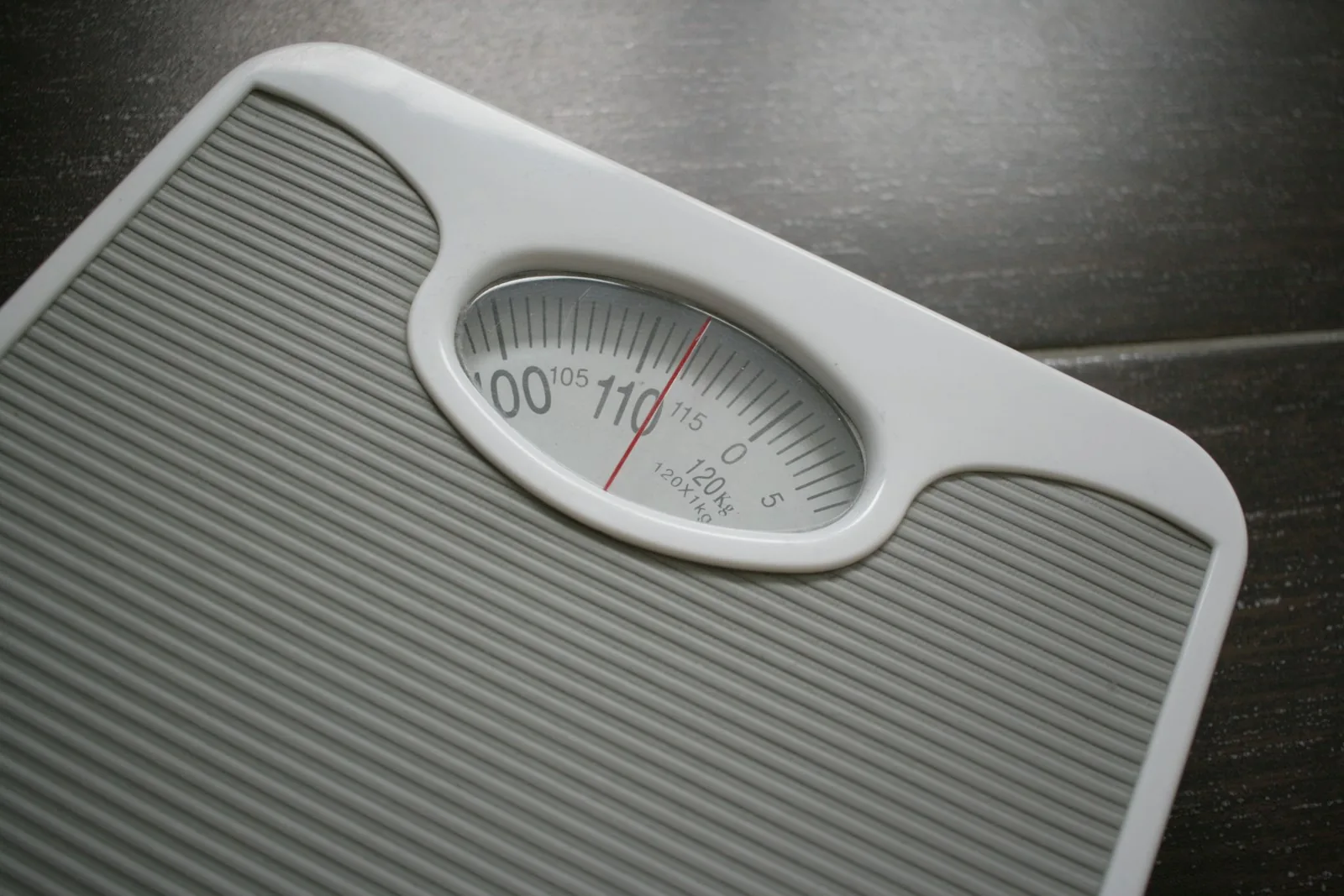 A mechanical bathroom scale with a dial ending at 120 kilograms