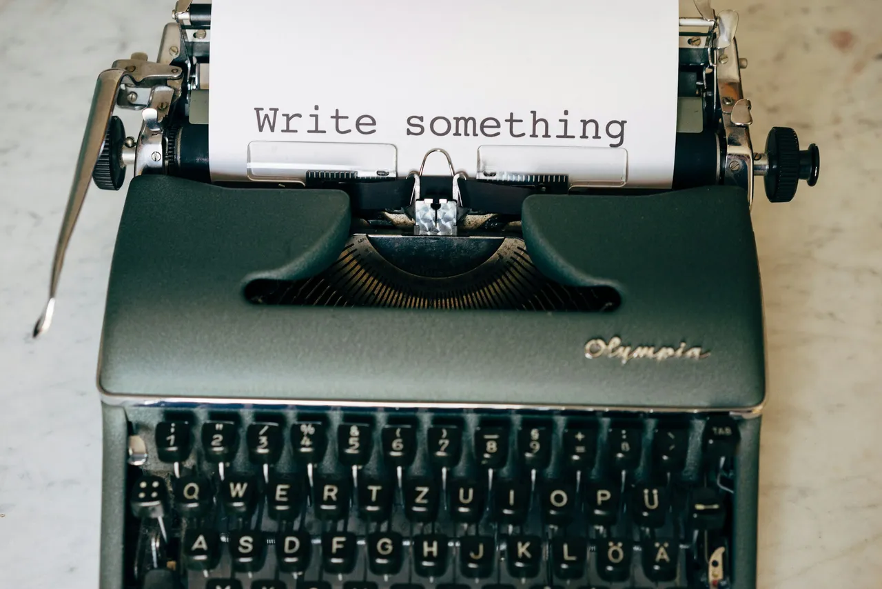 Olympia typewriter with a sheet of paper that reads Write something
