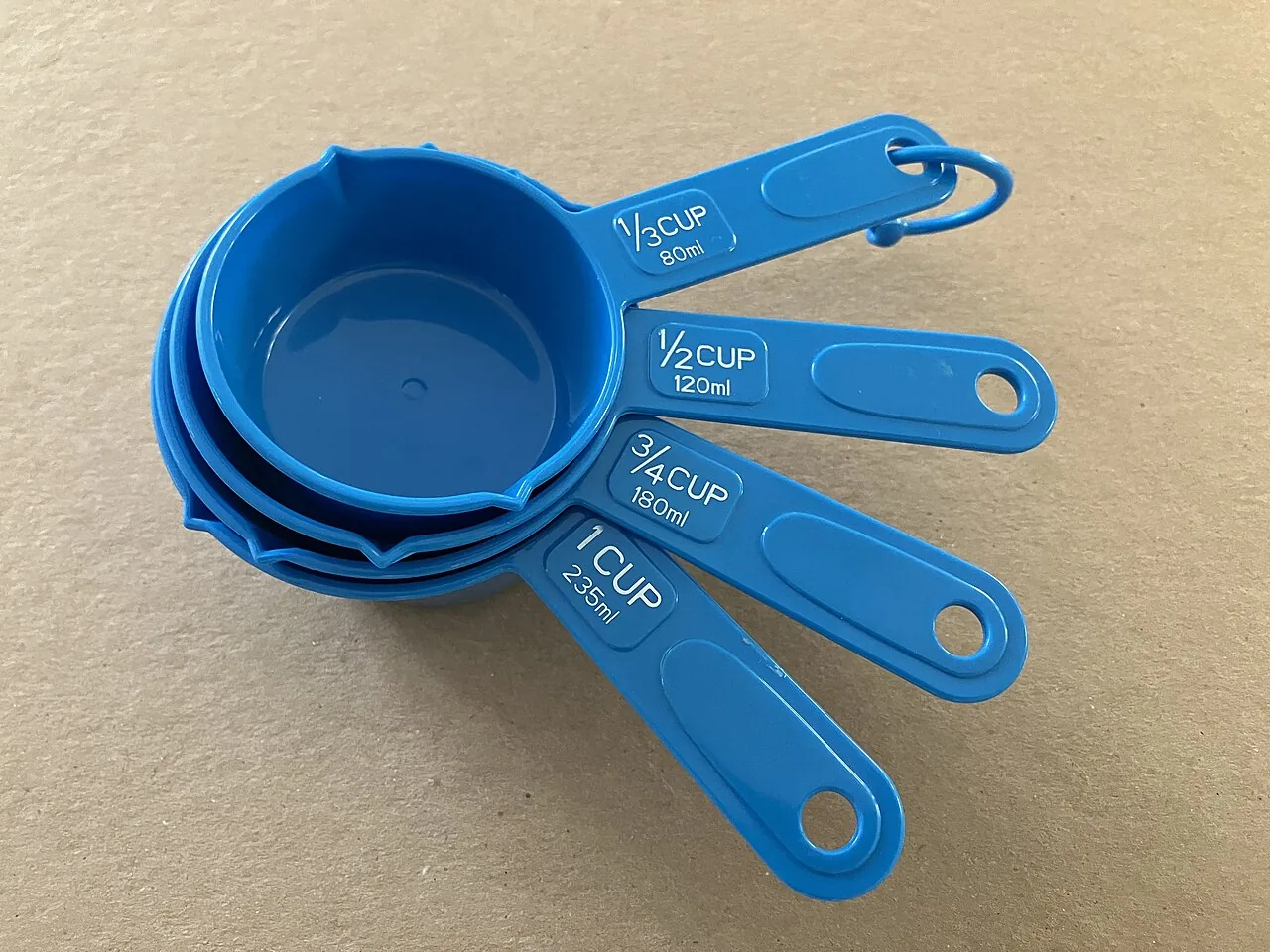 A nested set of four American measuring cups marked in cup fractions and millilitres