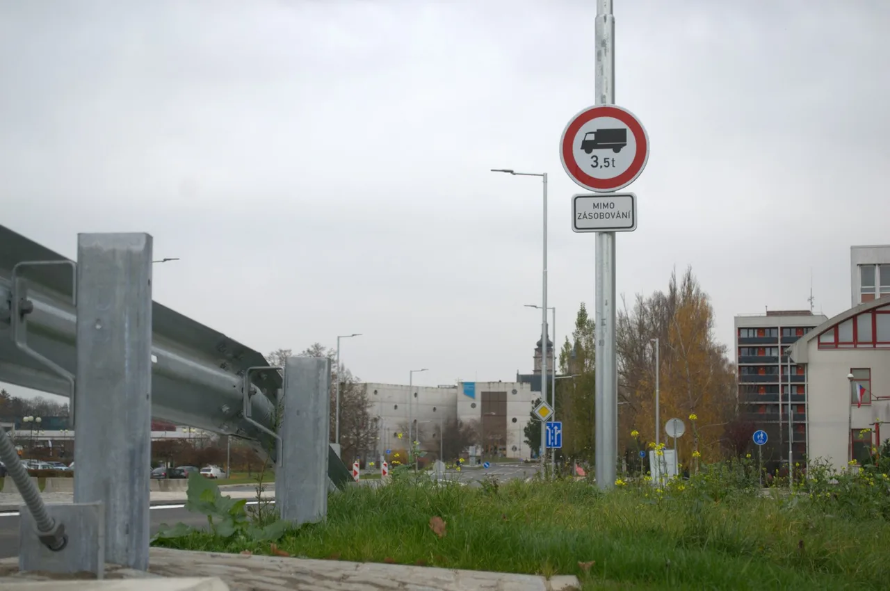 Okrągły znak z czerwoną obwódką, sylwetką ciężarówki i liczbą 3,5 t, zawieszony na słupie przy drodze