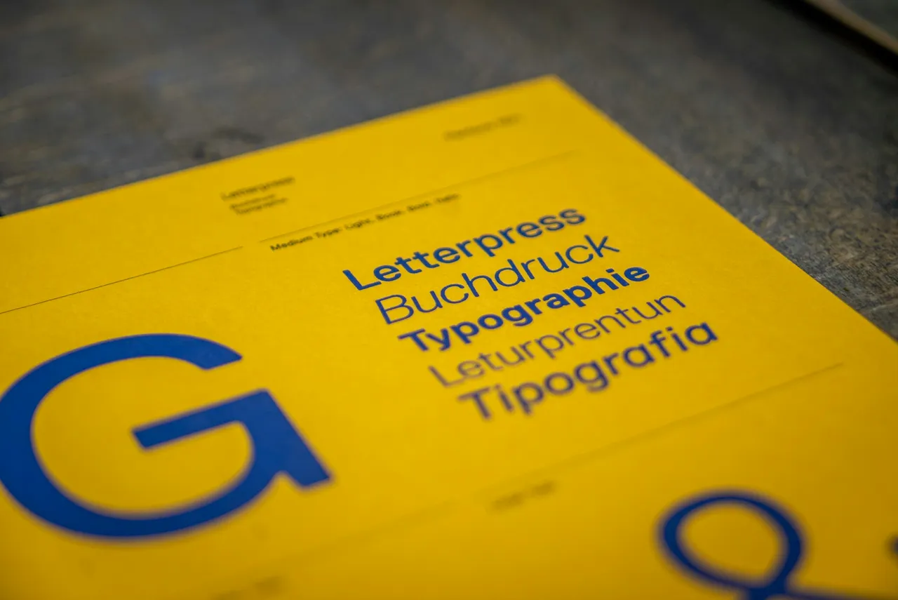 Planche de spécimen jaune avec un grand G, une esperluette et des mots en caractères plus petits