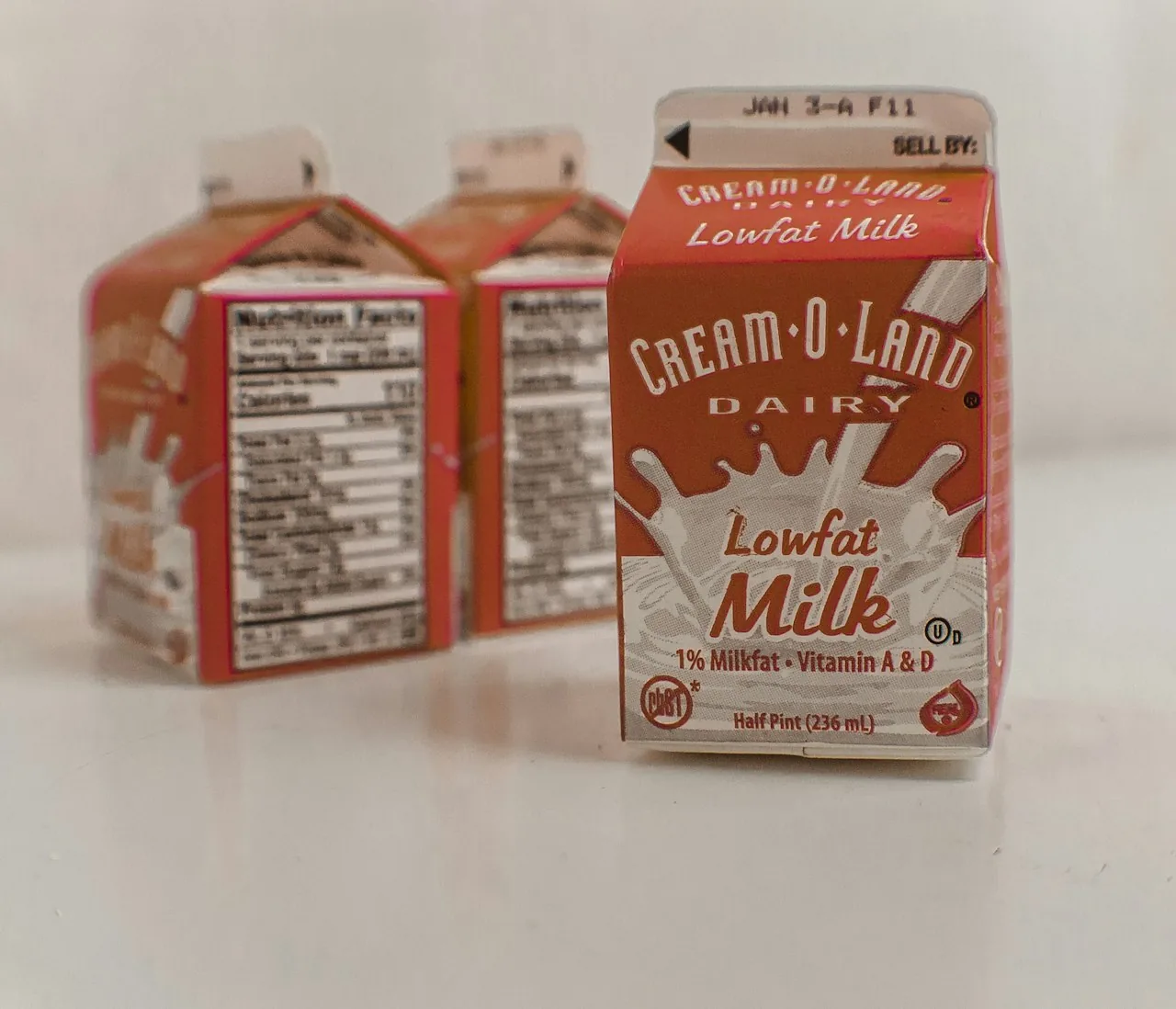 Drei kleine amerikanische Milchkartons, auf dem vorderen steht Half Pint 236 mL