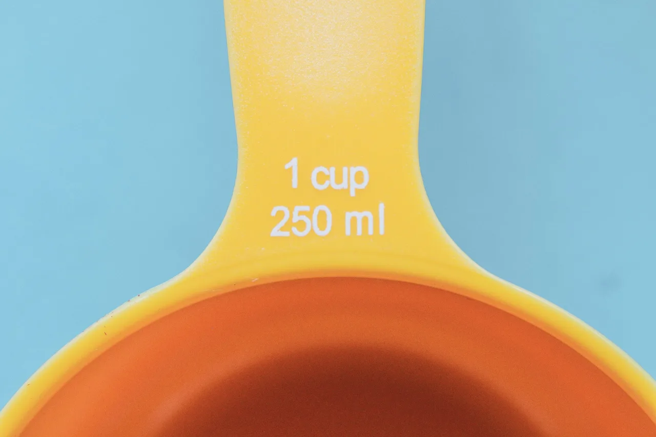 Close-up of the yellow handle of a measuring cup printed with 1 cup 250 ml