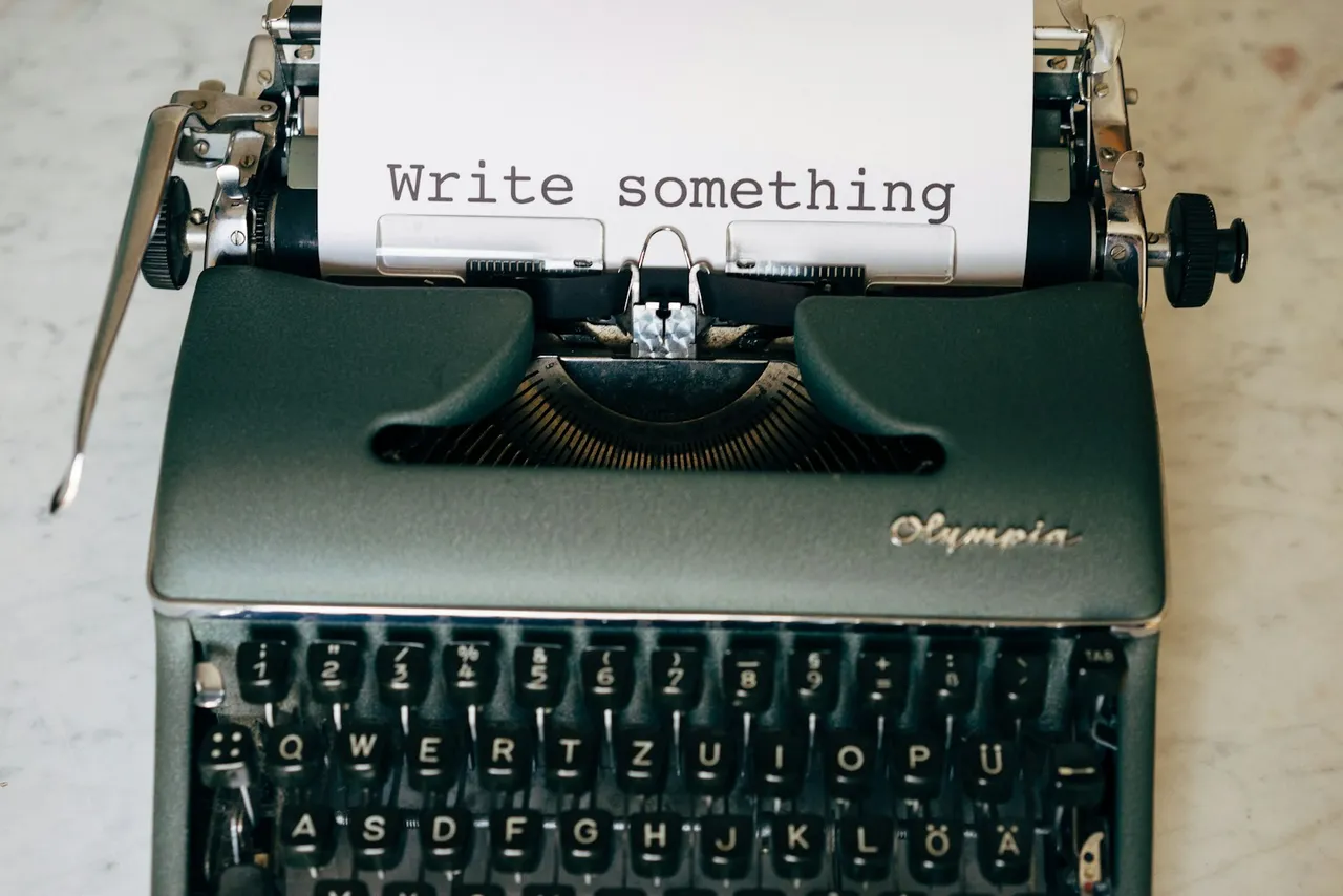 Máquina de escrever Olympia com uma folha onde se lê Write something